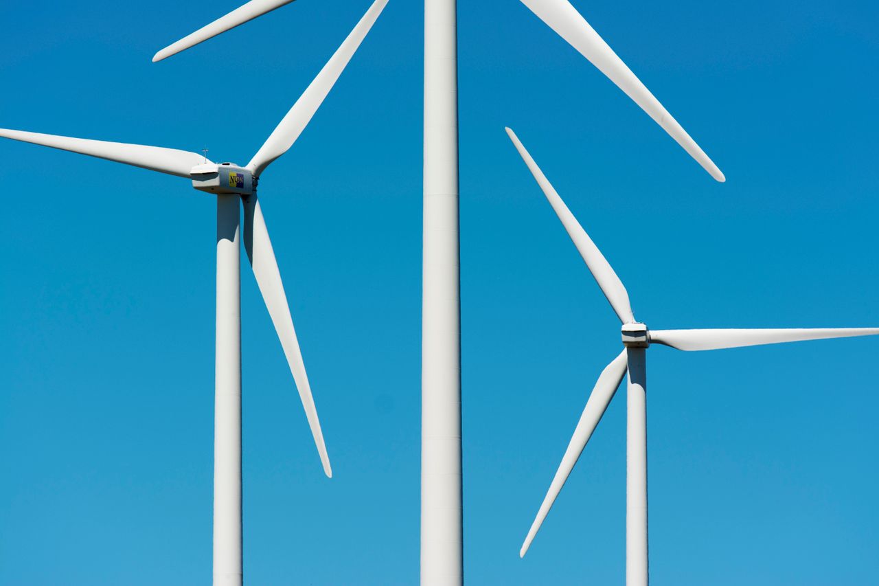 services-01 Close-up view of wind turbines generating clean energy against a clear blue sky.